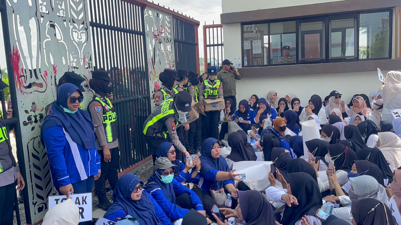 Buruh Demo Tolak KTR, Polwan Bagi Air Minum