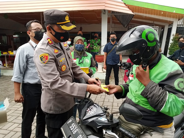 Polres Jember  dan URC Gojek Jember Gelar Aksi  Pembagian Masker, Vitamin dan Penyemprotan Desinfeck